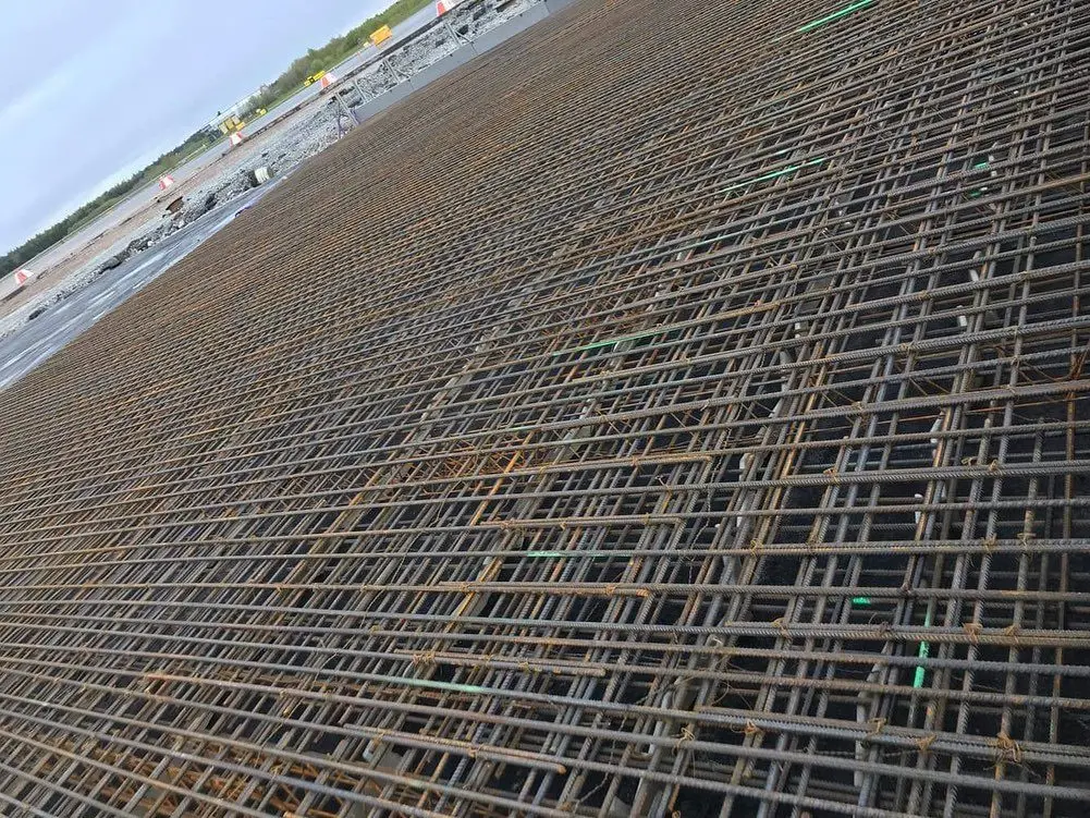 Flera överlappande armeringsjärn vid arbete för armering.